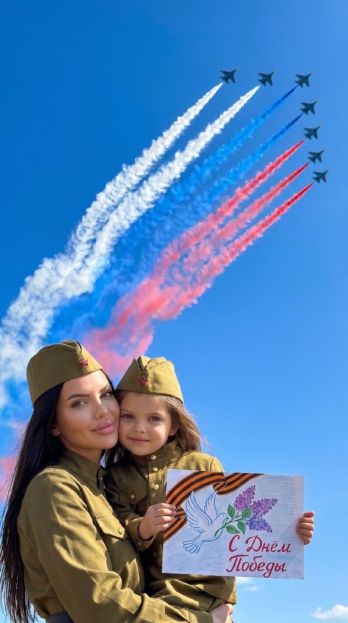 Мать и ребёнок на фоне неба в День Победы