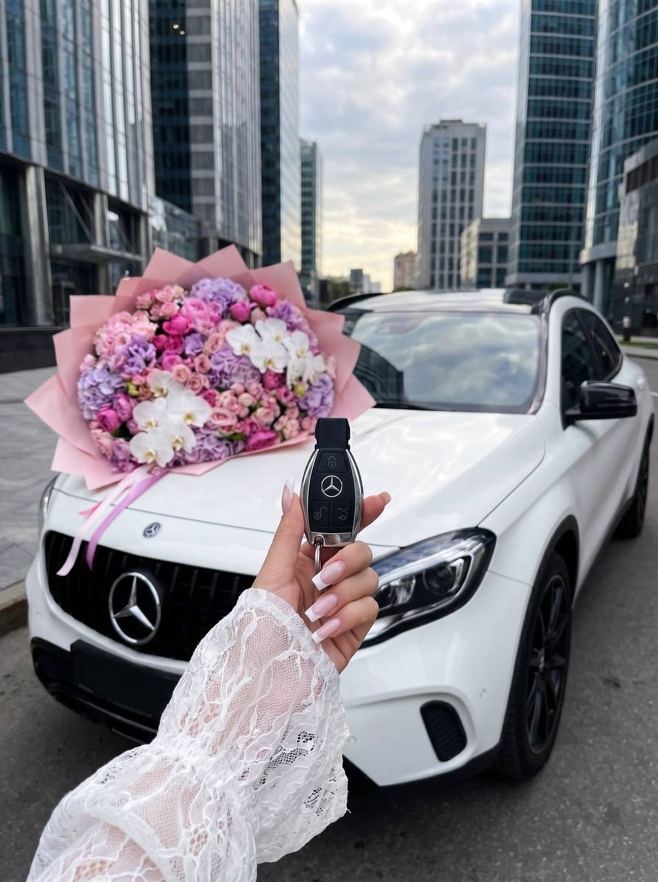 Элегантная женщина на капоте белого Mercedes