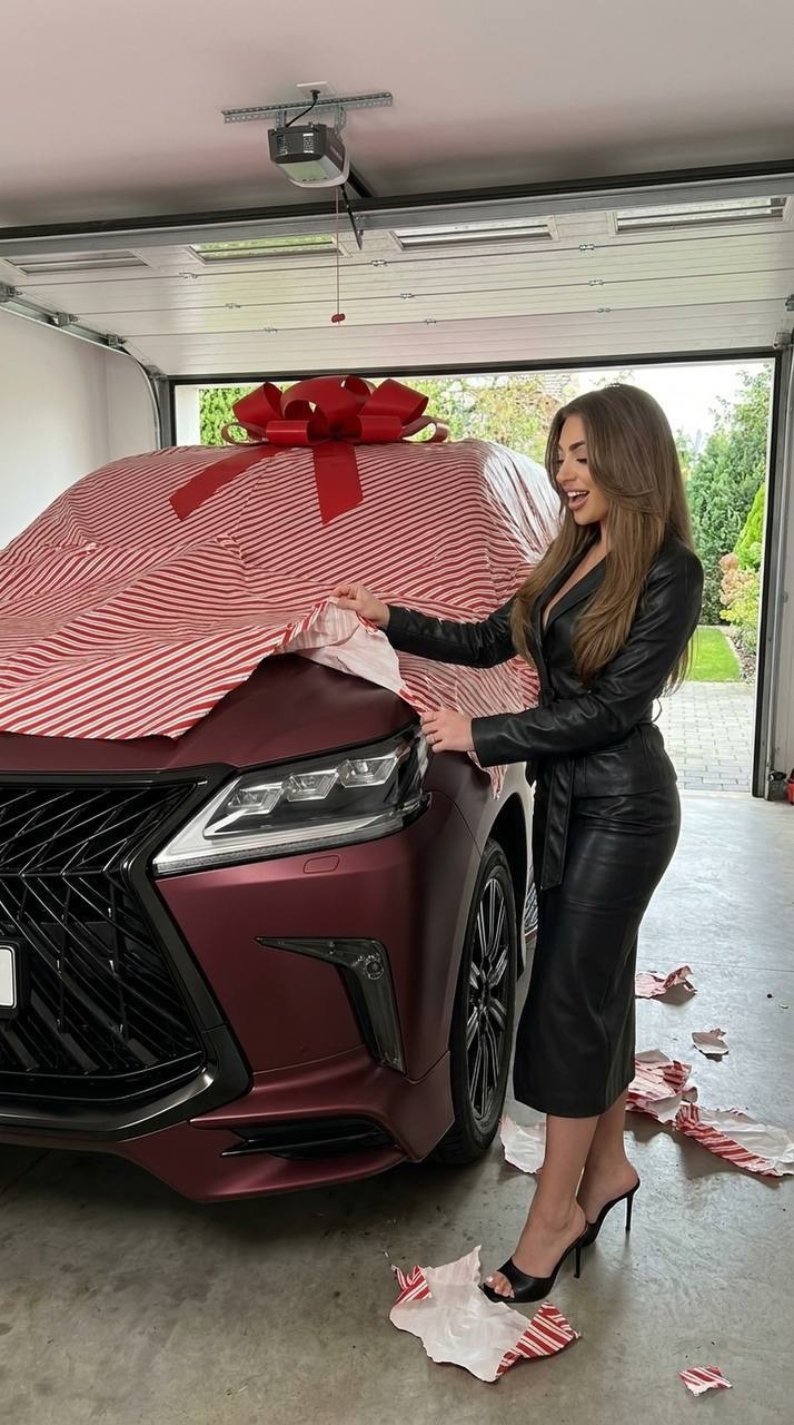 Женщина распаковывает бордовый Lexus LX570 в гараже