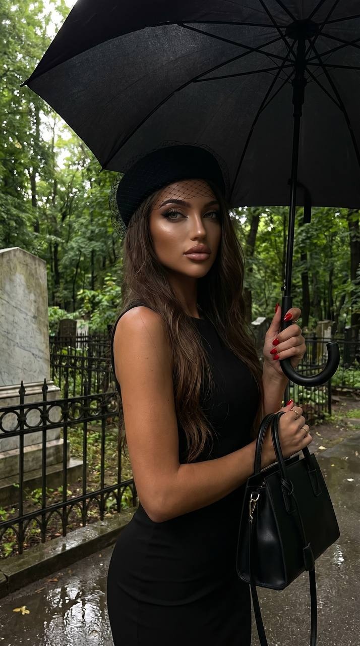 Элегантная женщина в чёрном в дождливом кладбище