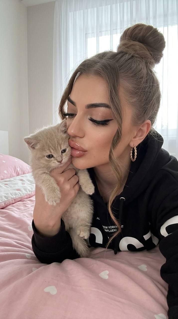 Селфи женщины с котёнком на розовой постели