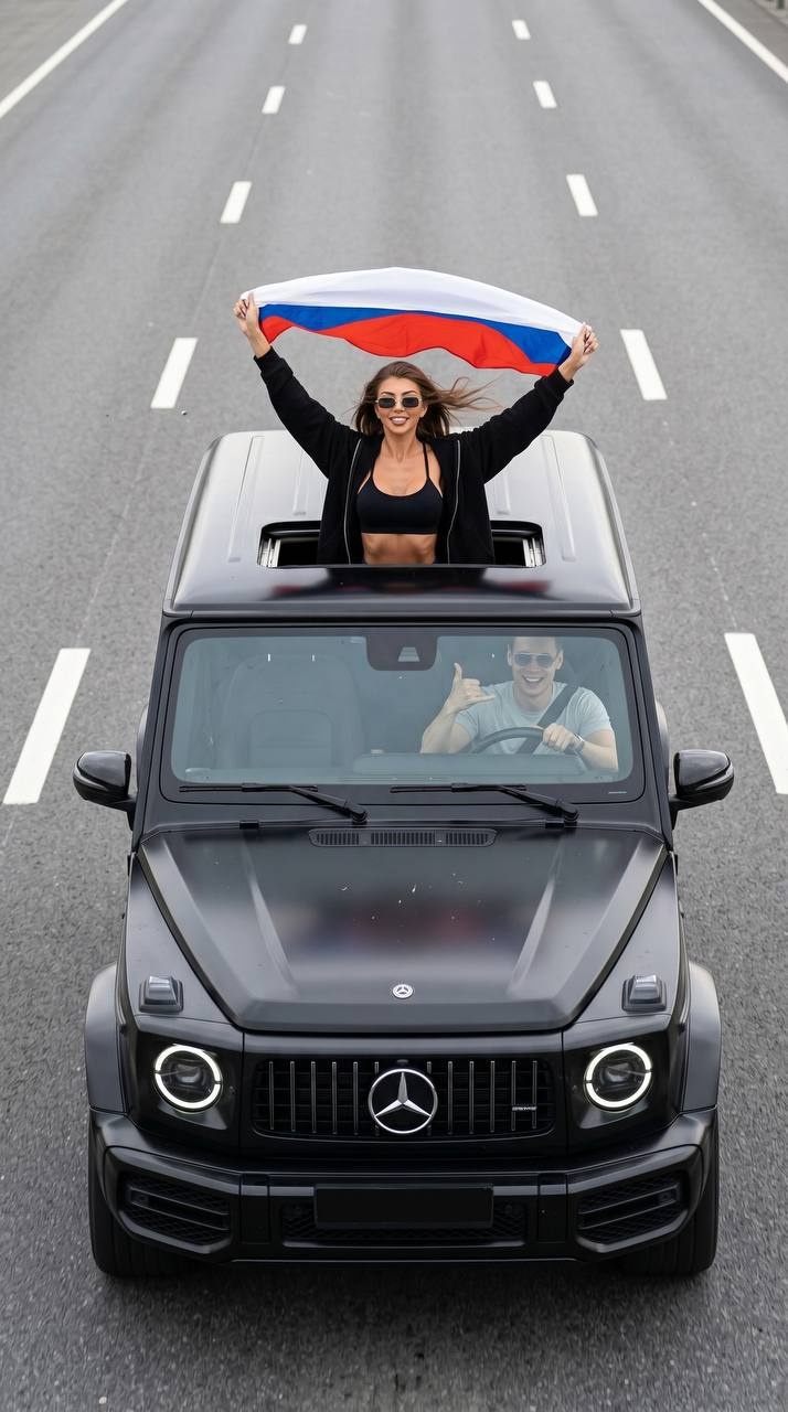 Чёрный Gelandewagen с флагом России на дороге