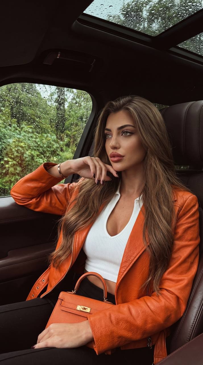 Женщина в кожаном салоне автомобиля у дождливого окна