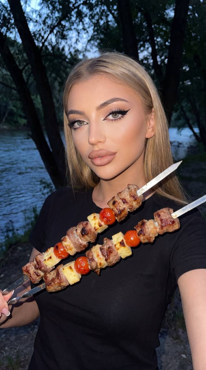 Девушка делает селфи у реки вечером