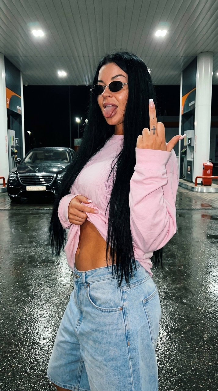 Девушка в пастельном streetwear у ночной заправки